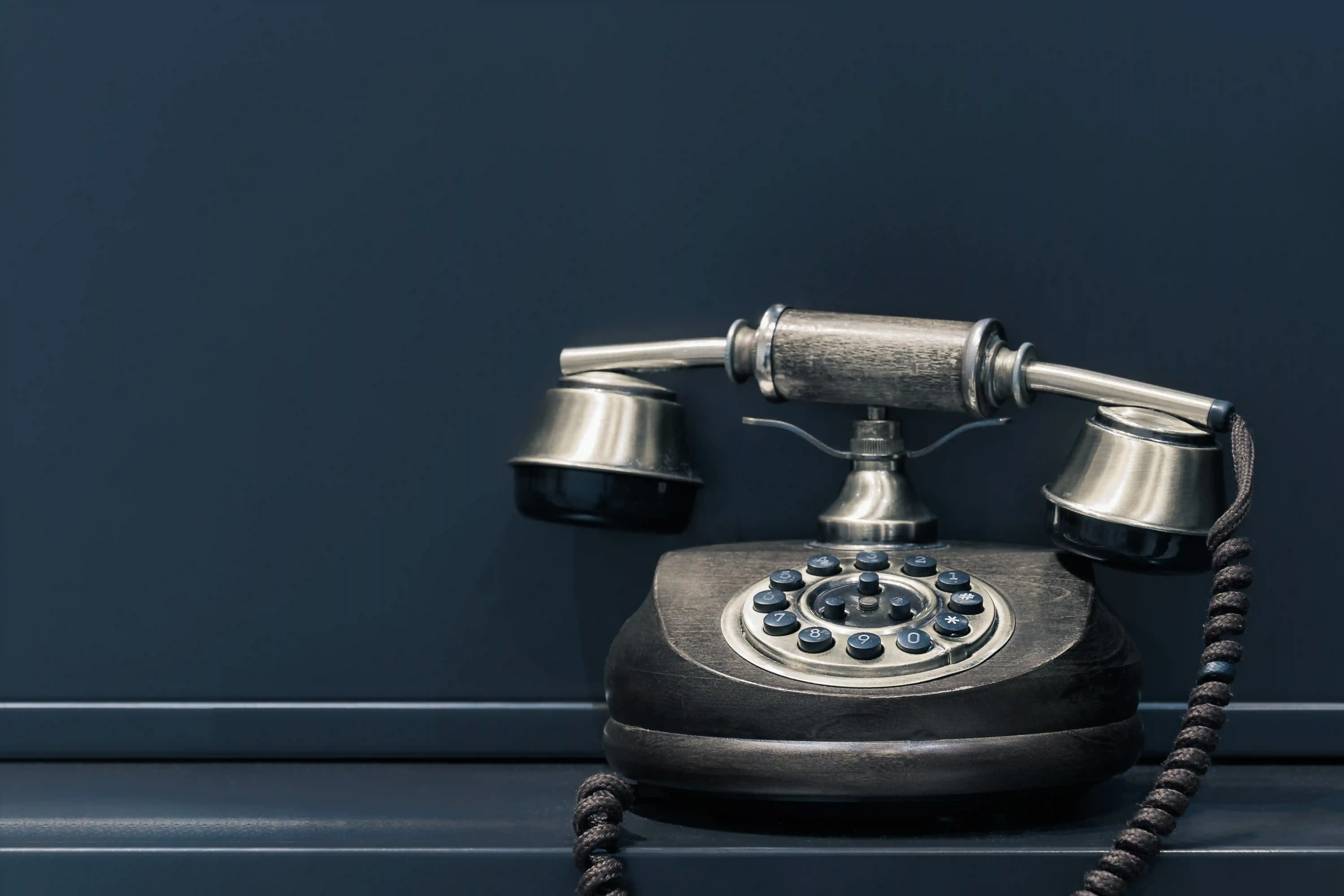 A rustic press button telephone designed to look like a turn-to-dial antique with liftable receiver.